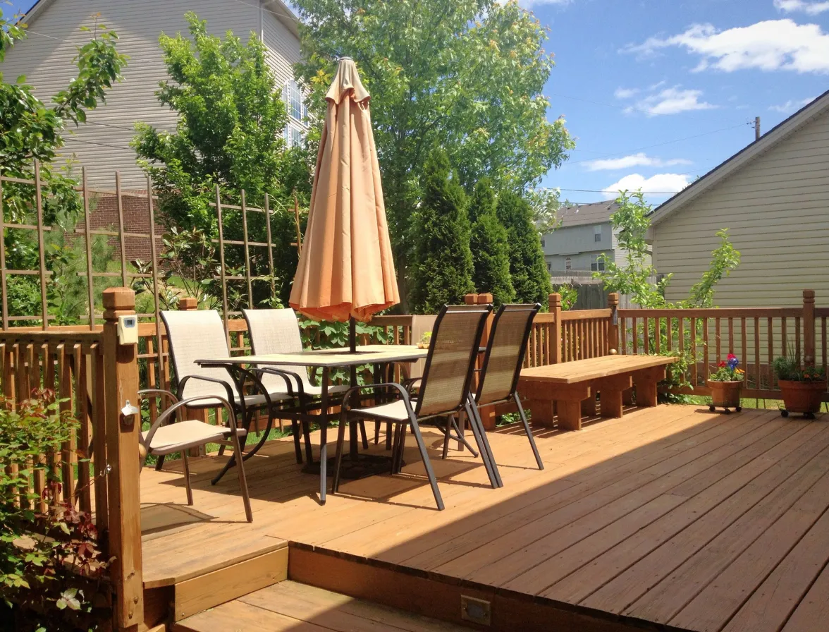 Finished wood deck patio with outdoor dining area and backyard garden
