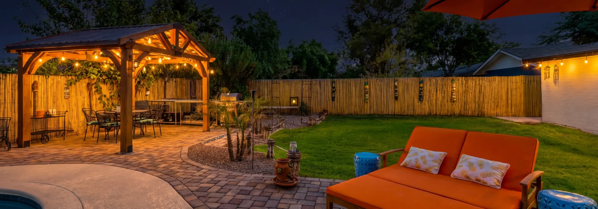 Backyard patio construction in Los Angeles at night with pergola lighting, paver patio, and outdoor dining area