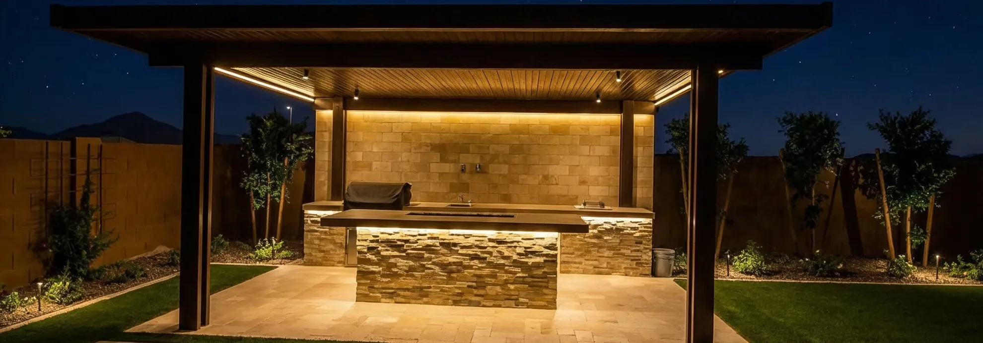 Paver patio hardscape in Los Angeles at night with outdoor kitchen, lighting, and modern entertainment space