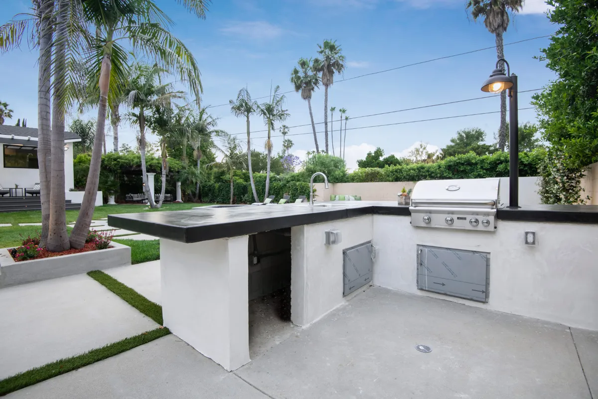 Outdoor kitchen and BBQ area in Los Angeles backyard with modern countertop and built-in grill installation